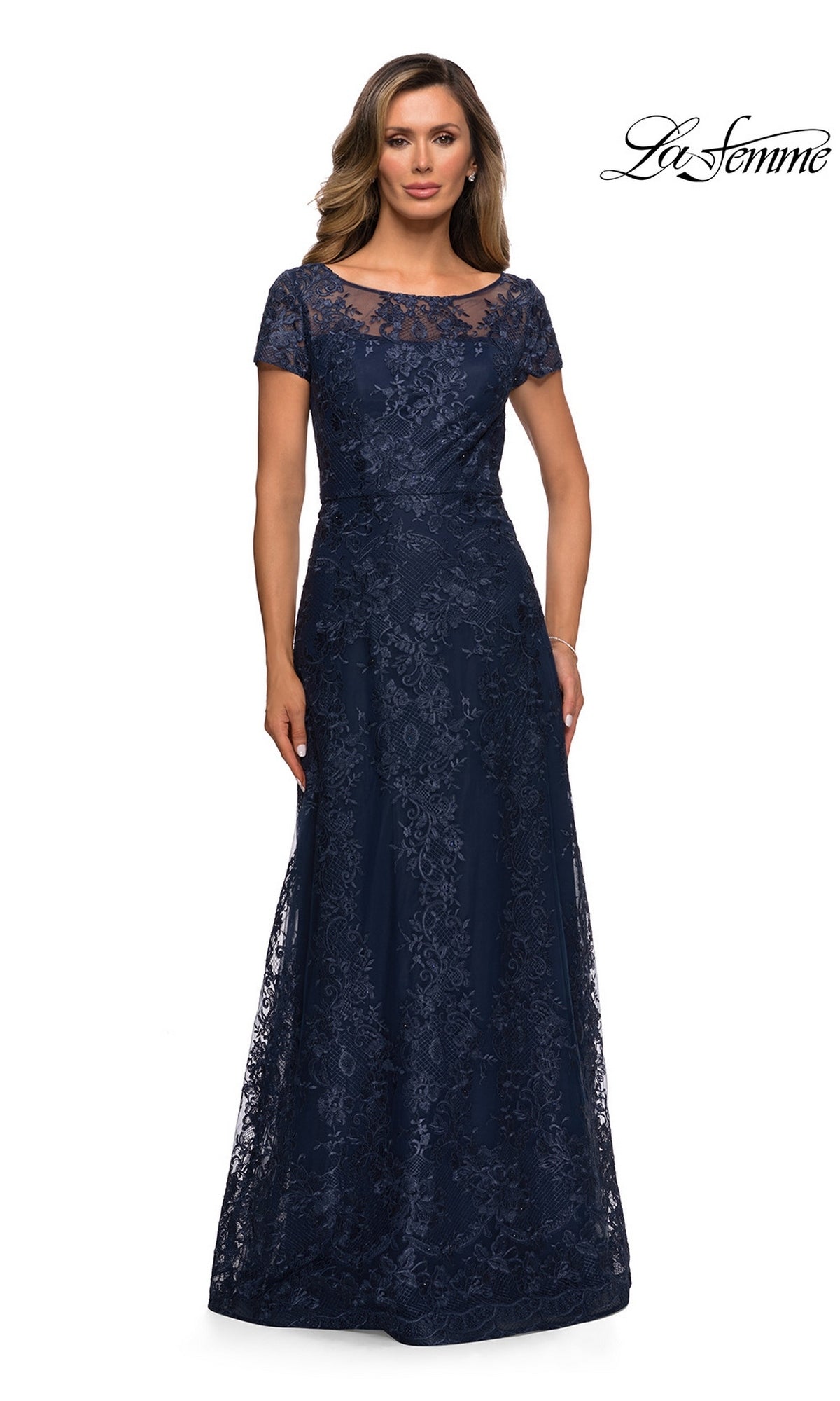 Woman in a floor-length navy Long Formal Dress: La Femme 27935 with floral lace, short sleeves, and an illusion neckline. “La Femme” logo appears top right.